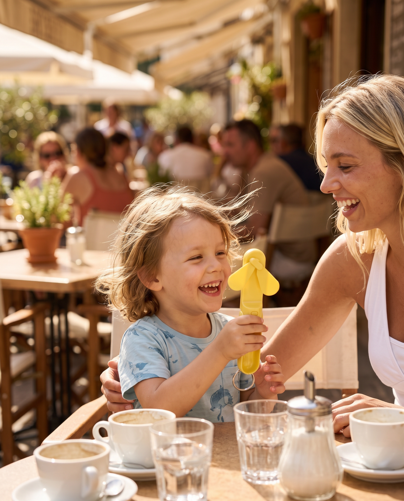 A child cooling off with the Pocket Fan at a cafe terrace