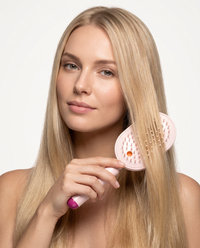 Woman combing her hair with the SilkMist Comb in Pink
