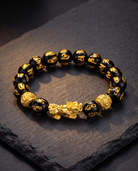 Feng Shui obsidian bracelet on a dark slate surface