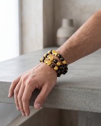 Man wearing a stack of Feng Shui obsidian bracelets on his wrist